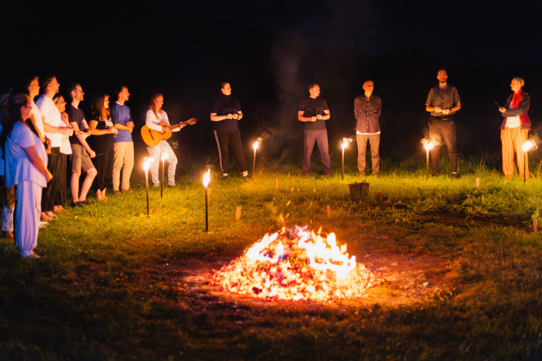 Die Gruppe steht bei Nacht mit Fackeln zusammen
